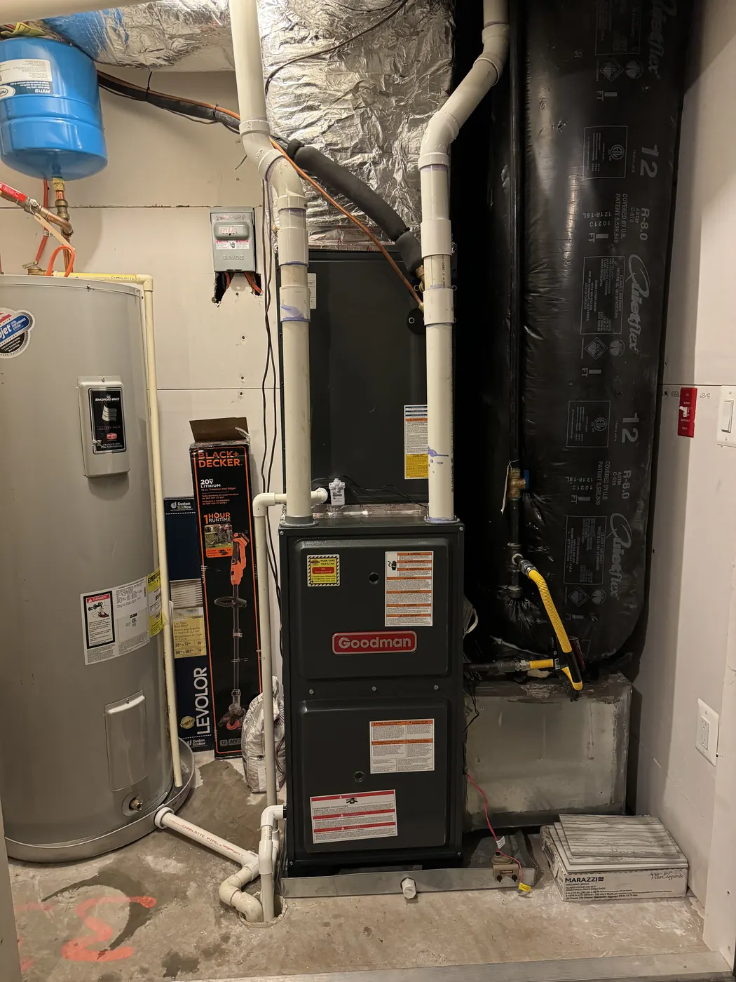 A furnace and water heater installed together in a utility closet