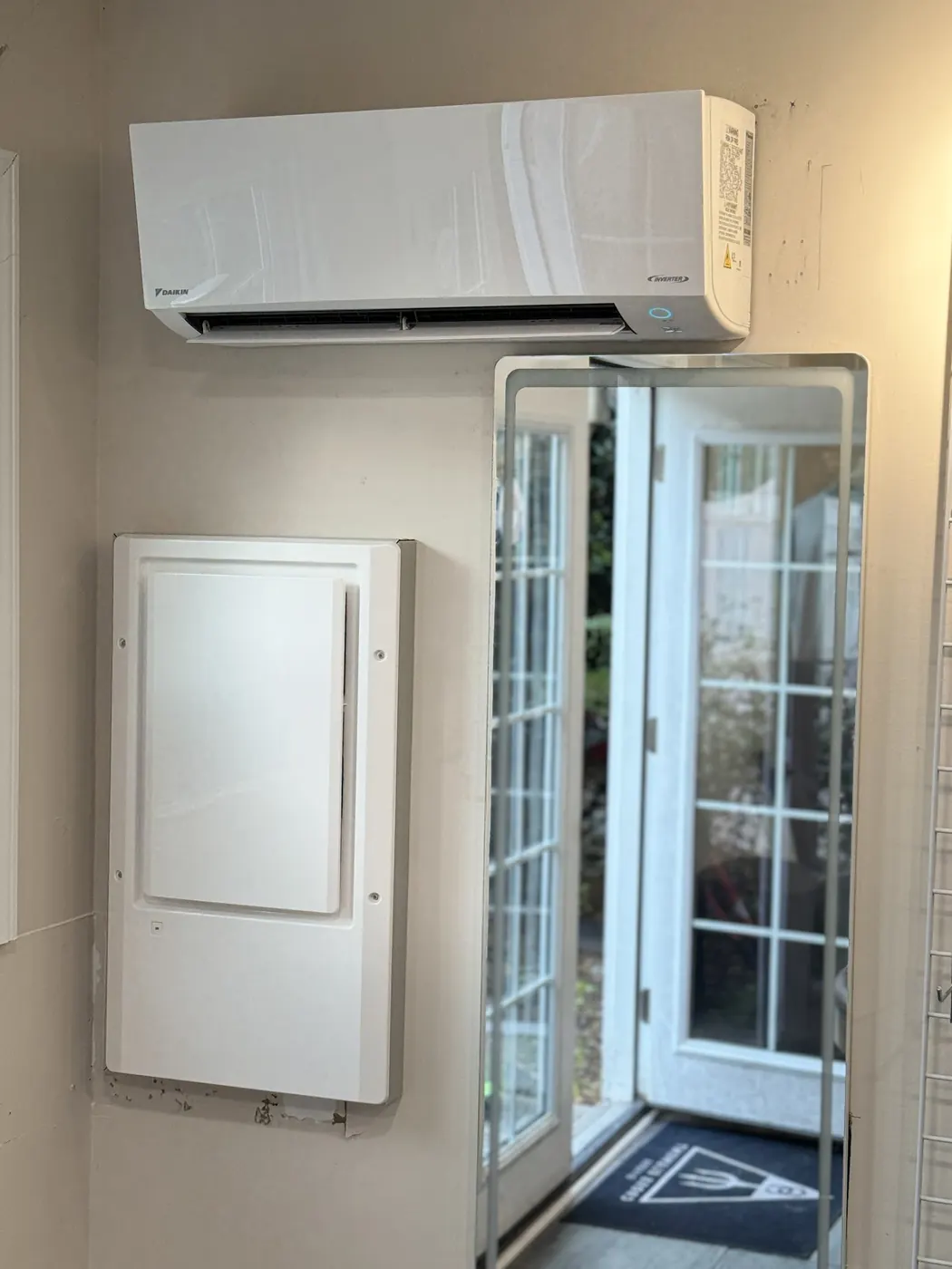 A Daikin ductless wall unit mounted above a doorway leading out to a patio