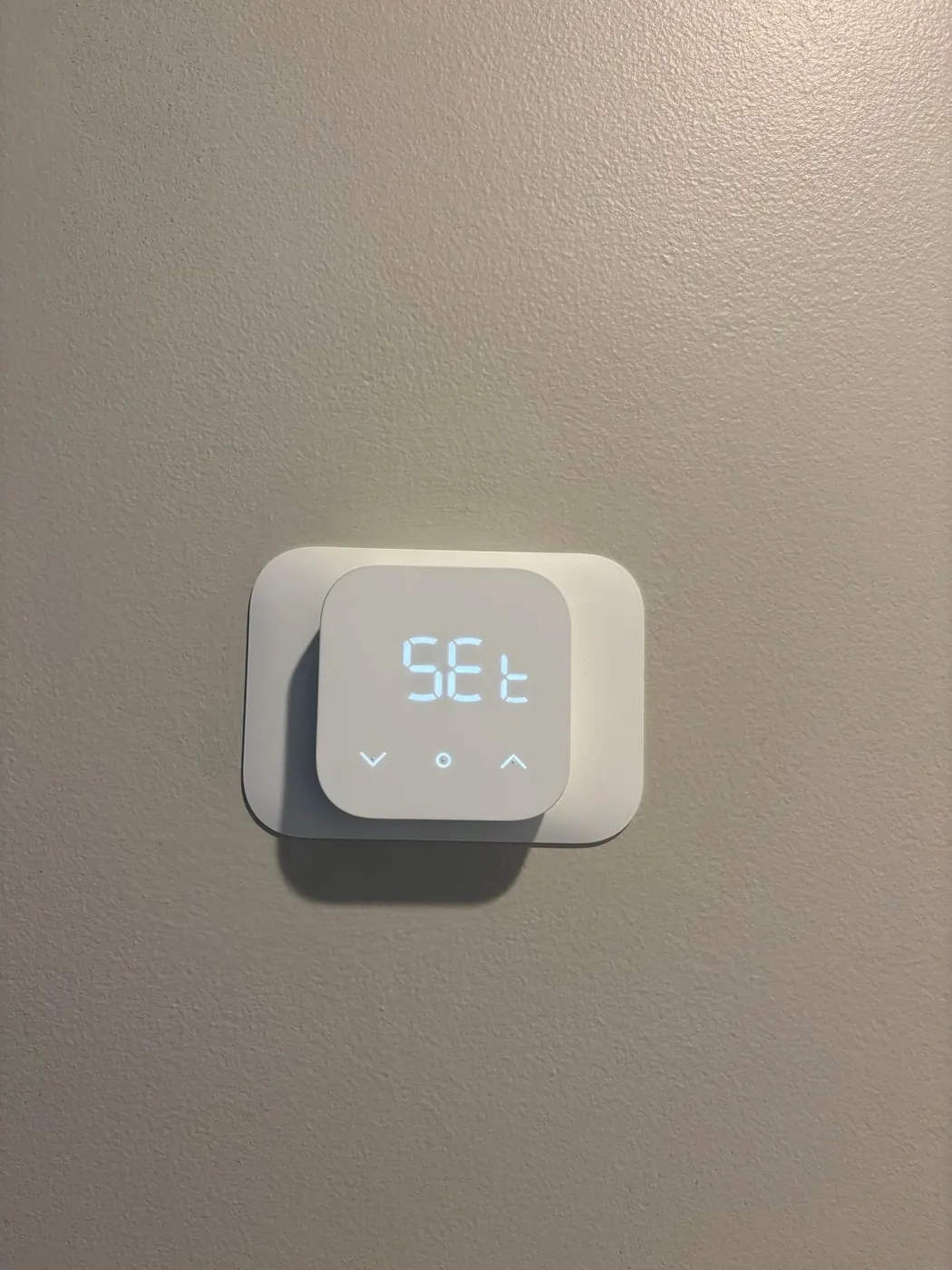 A new digital thermostat mounted on a gray wall